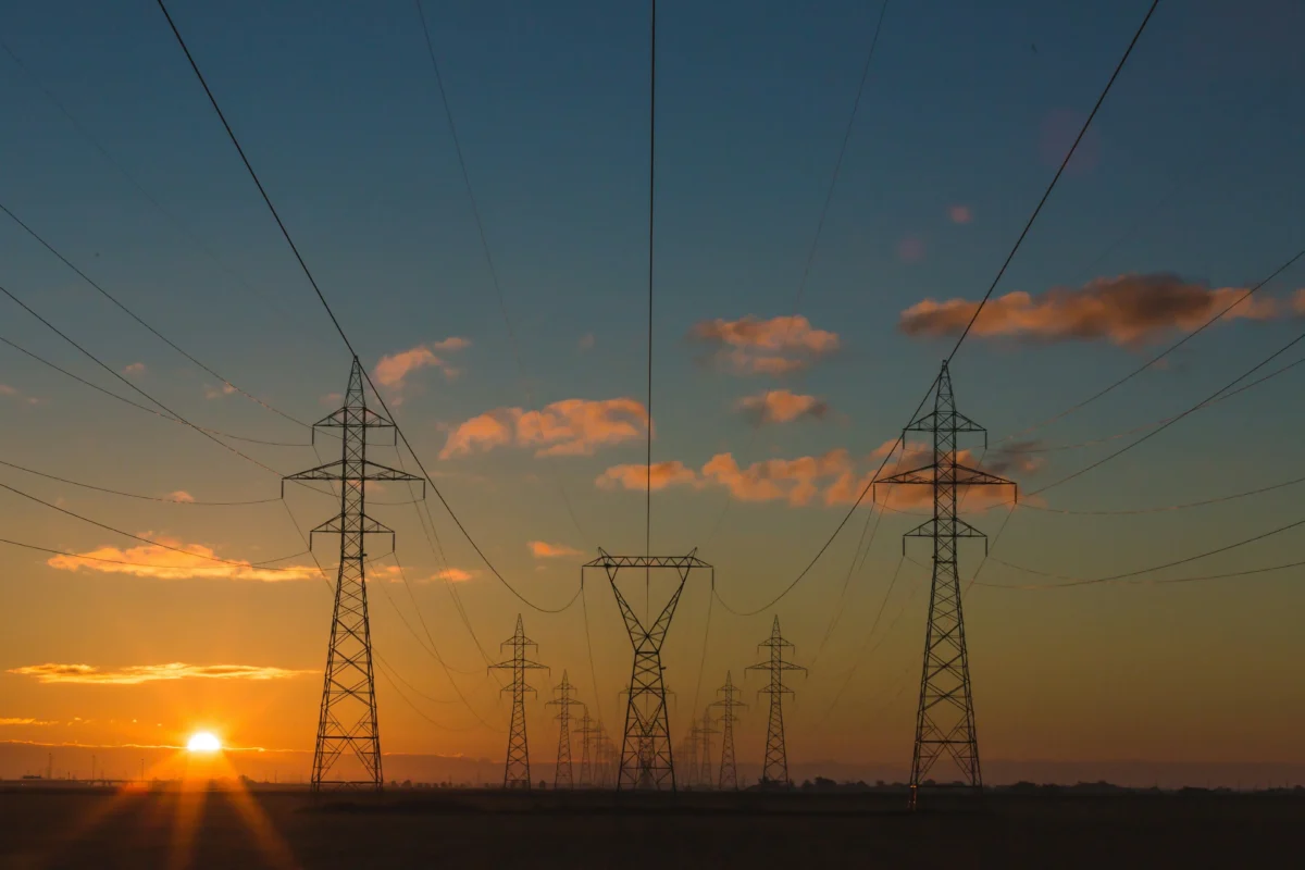 Photo of the sunsetting behind electrical lines.