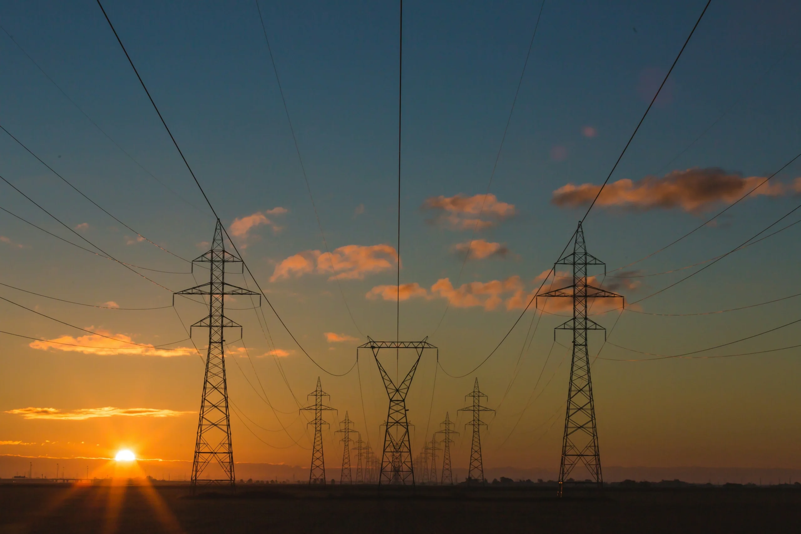 Photo of the sunsetting behind electrical lines.